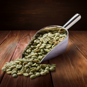 Green coffee beans in a scoop on a wooden table